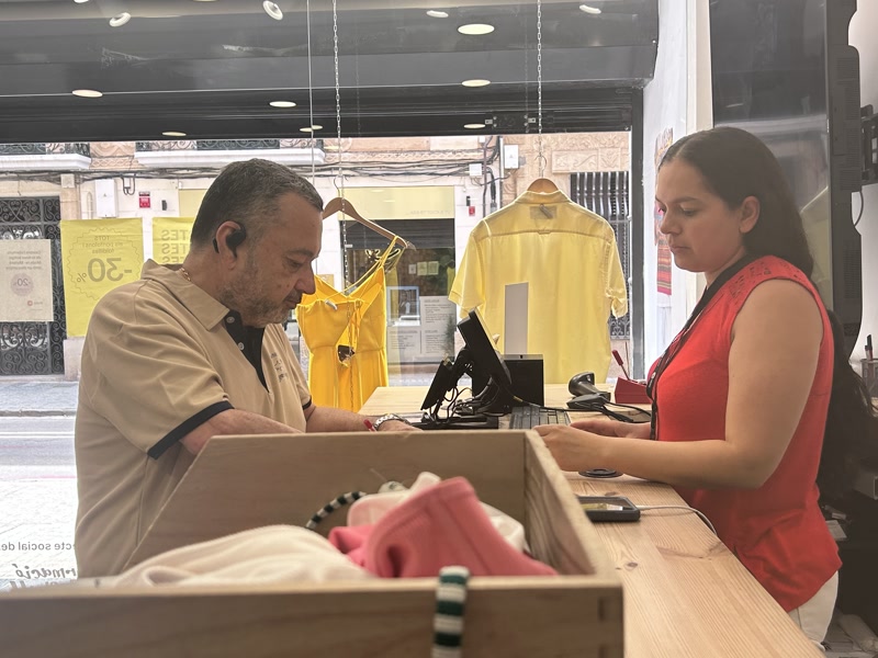 Una de les treballadores de Moda-re atenent un client
